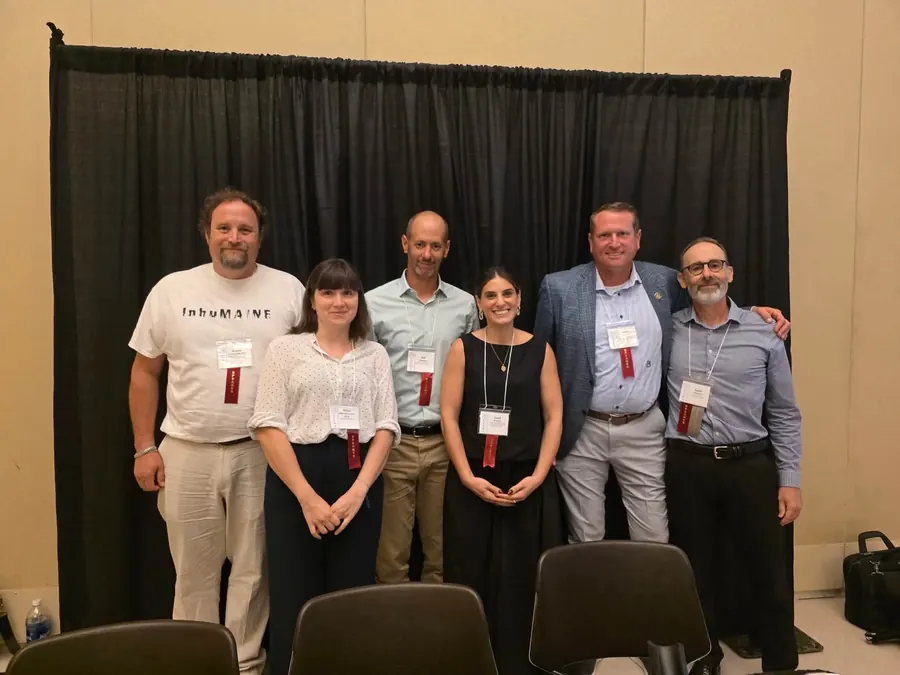 Speakers gather after a conference screening and panel conversation.